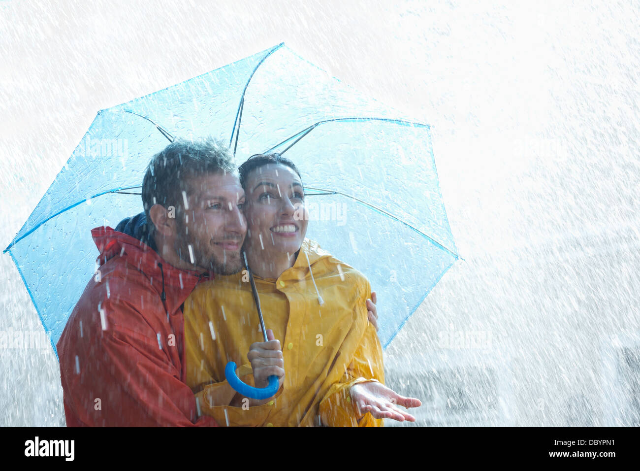 Happy couple under umbrella in rain Stock Photo Alamy