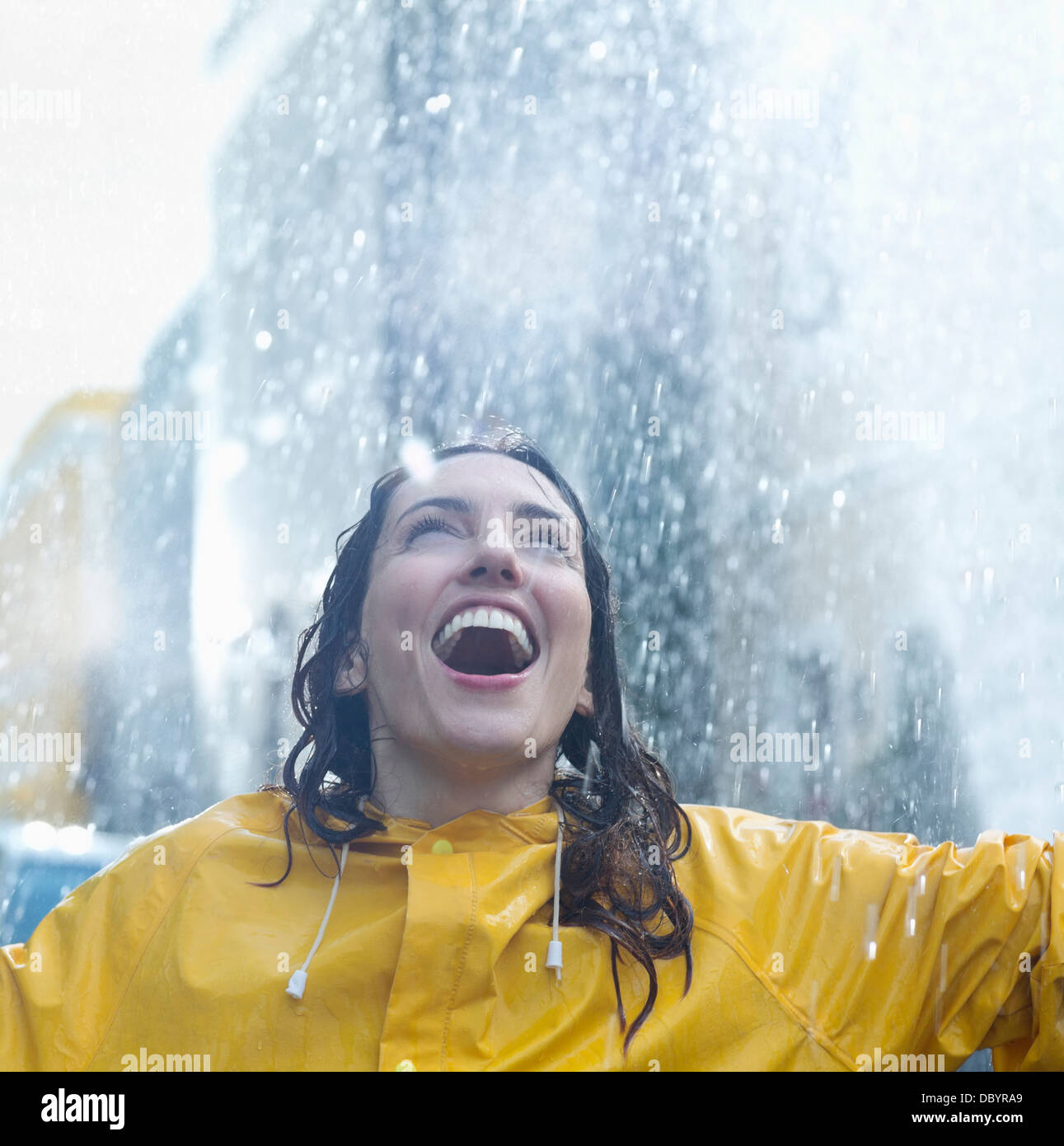 Enthusiastic woman standing in rain Stock Photo