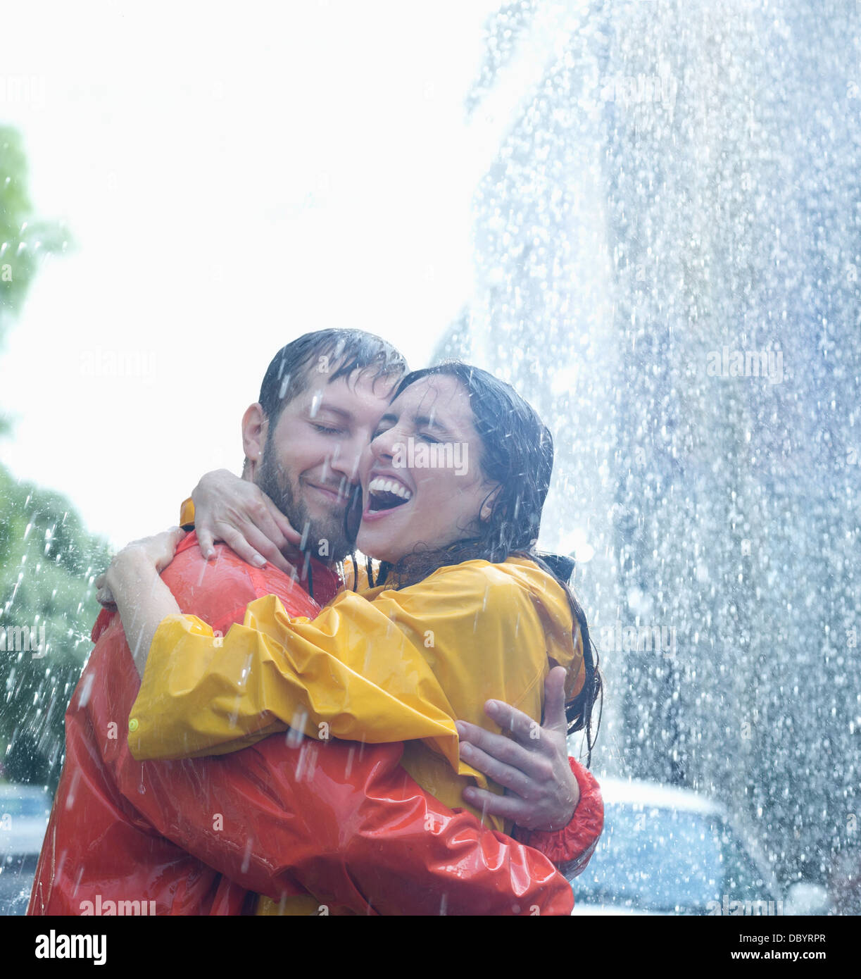 Happy couple hugging in rain Stock Photo