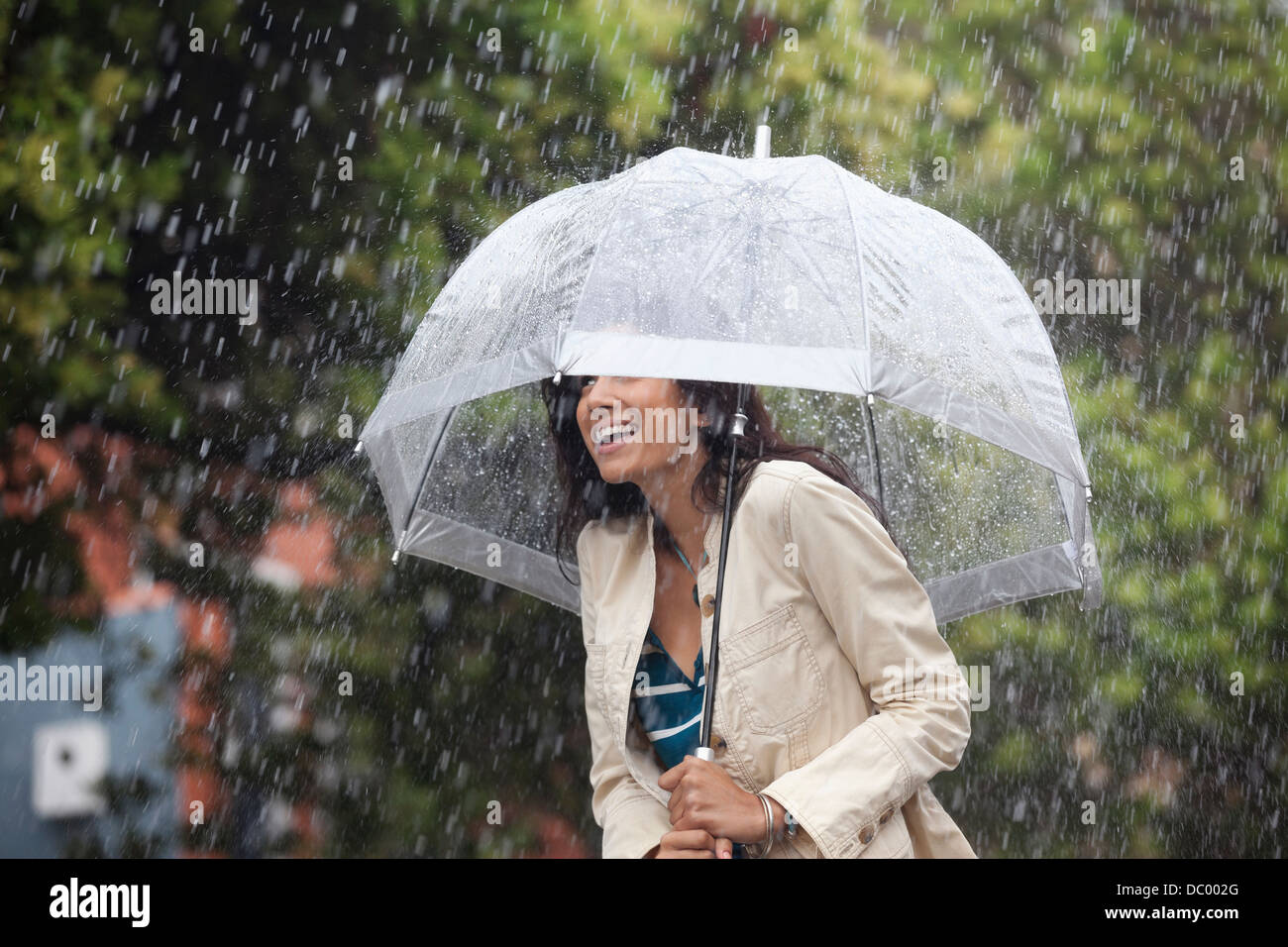 Happy woman under umbrella in rain Stock Photo