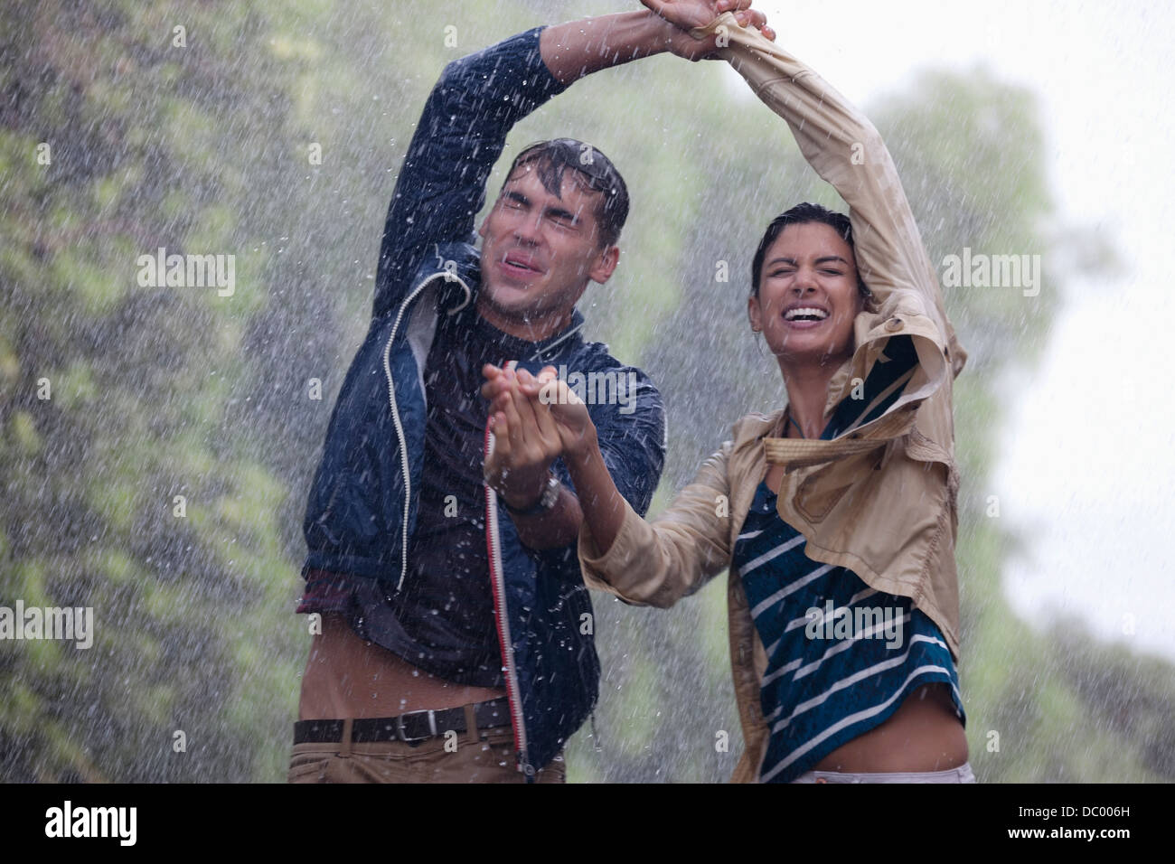 Happy couple dancing in rain Stock Photo