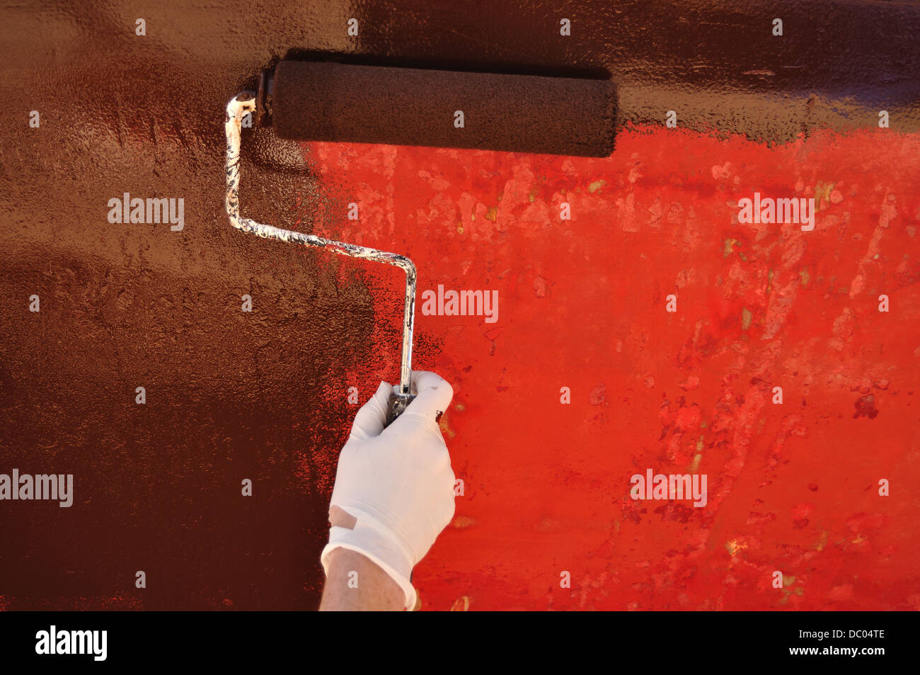 Painting a boat hull with a roller Stock Photo Alamy