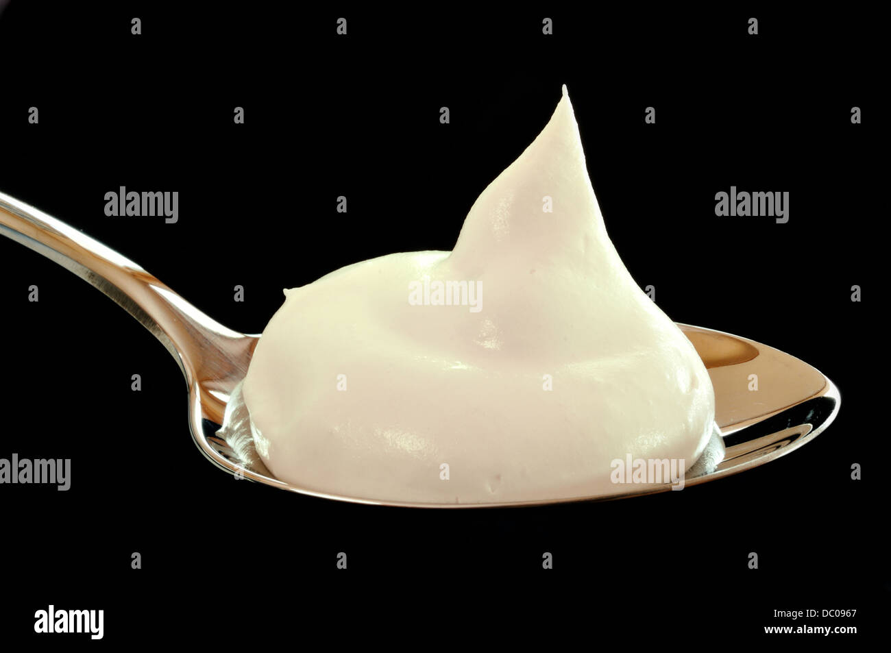 Whipped cream on a spoon on a black background close up Stock Photo