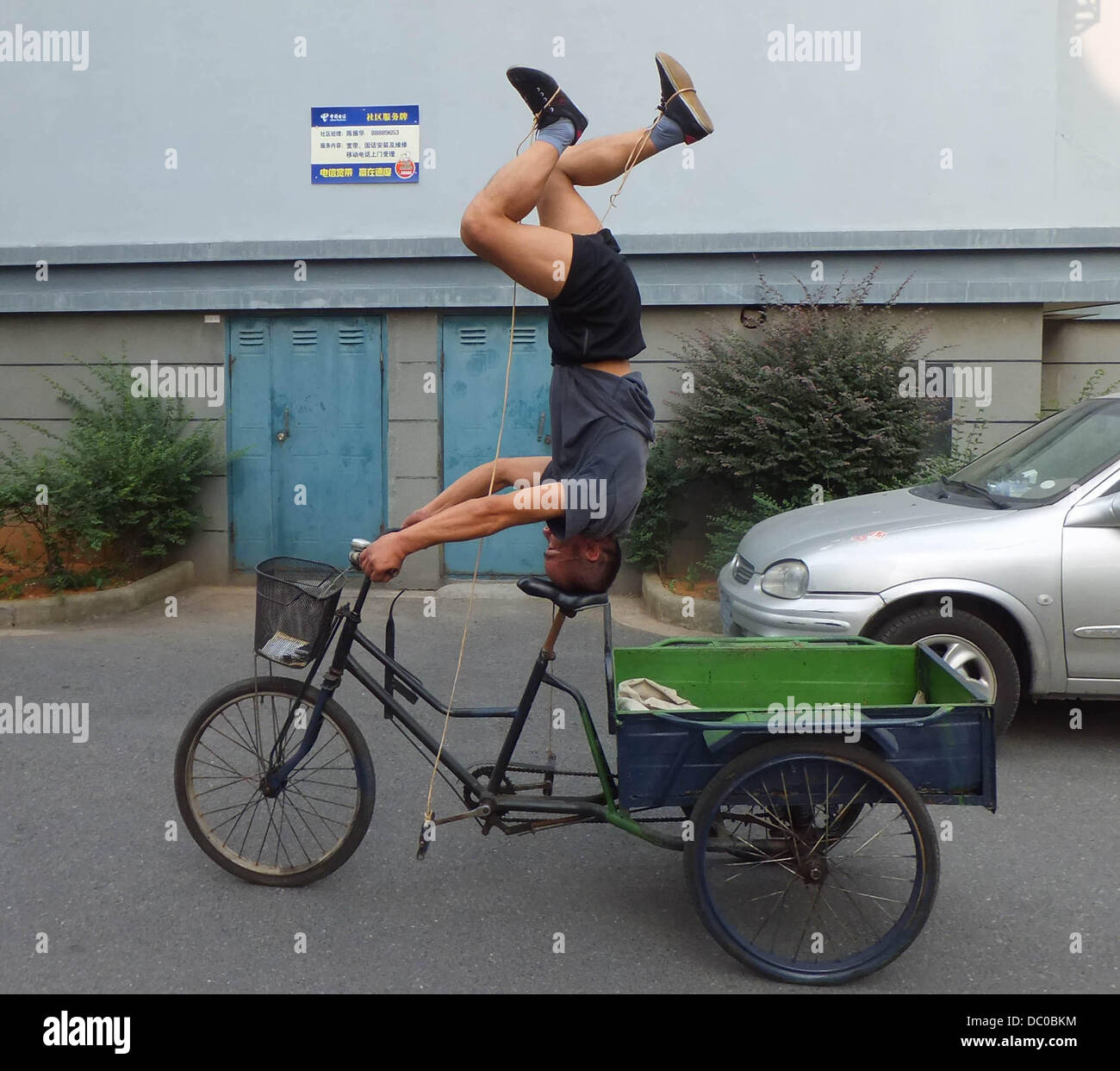 Upsidedown bike riding Mr Zhu rides his bike upside down a street in
