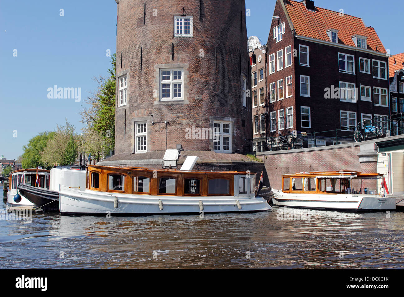 Amsterdam Netherlands Holland Europe exterior facade typical canal houses and tour boats along the Amstel Canal Stock Photo