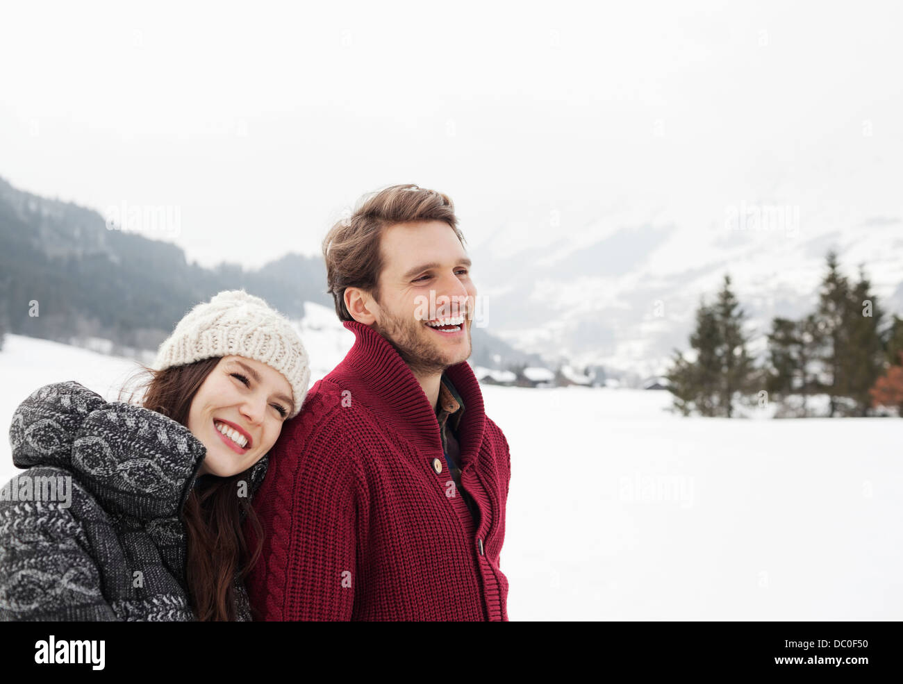 Happy couple in snowy field Stock Photo