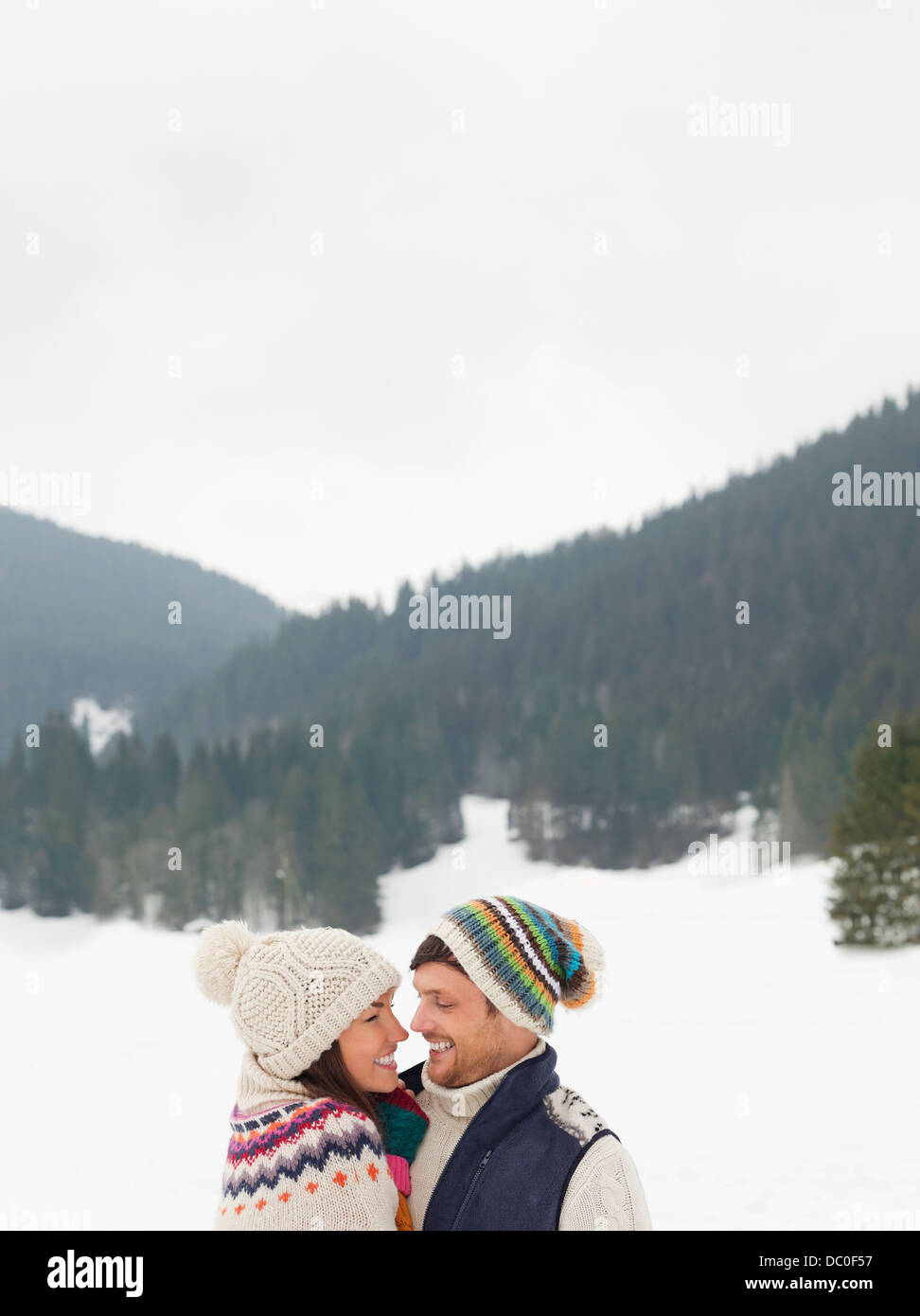 Happy couple face to face in snowy field Stock Photo