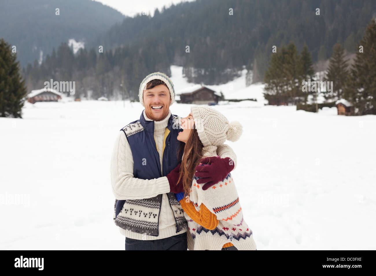 Couple hugging and laughing in snowy field Stock Photo - Alamy
