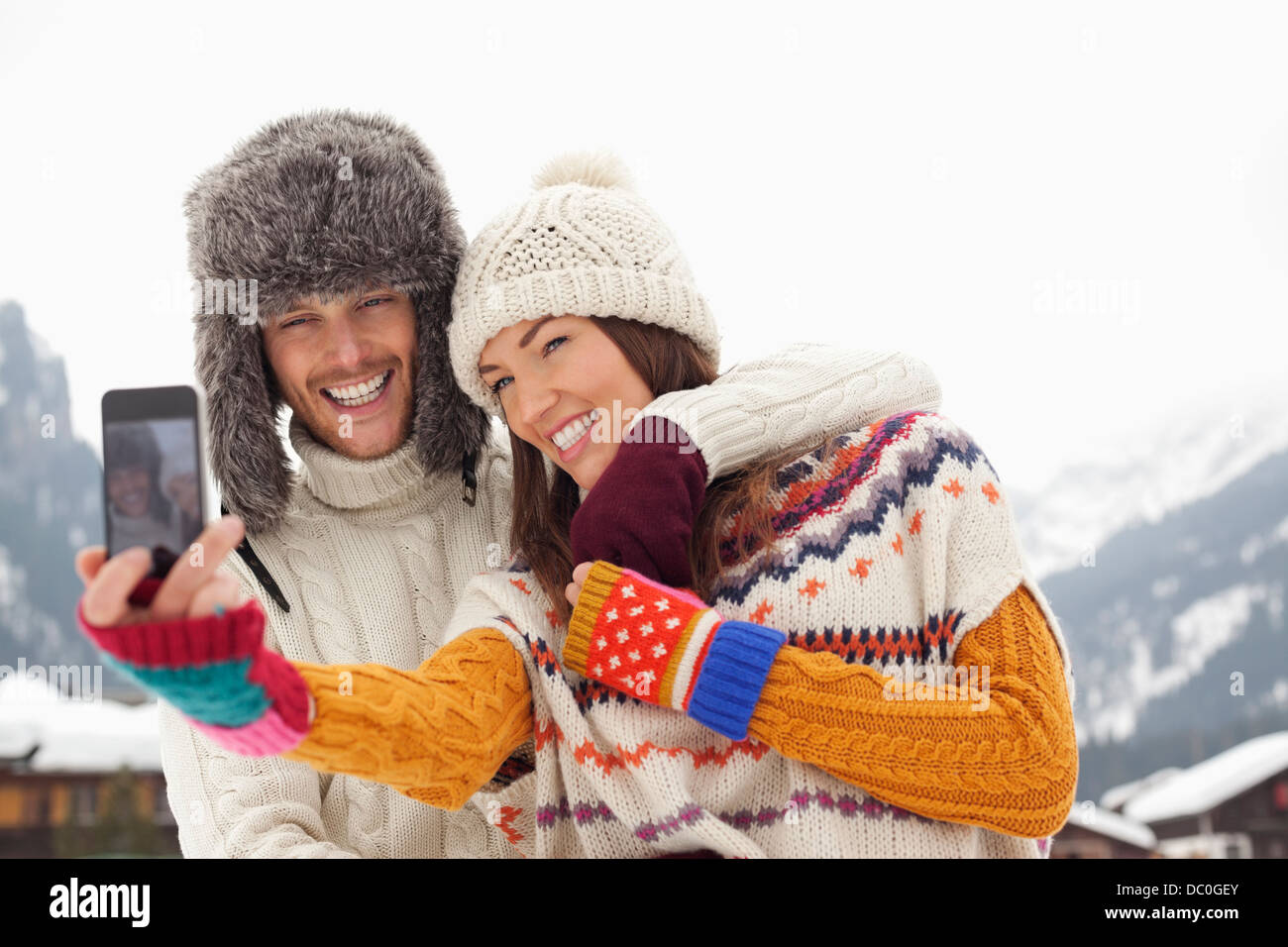 Happy couple taking self-portrait with camera phone near mountains Stock Photo