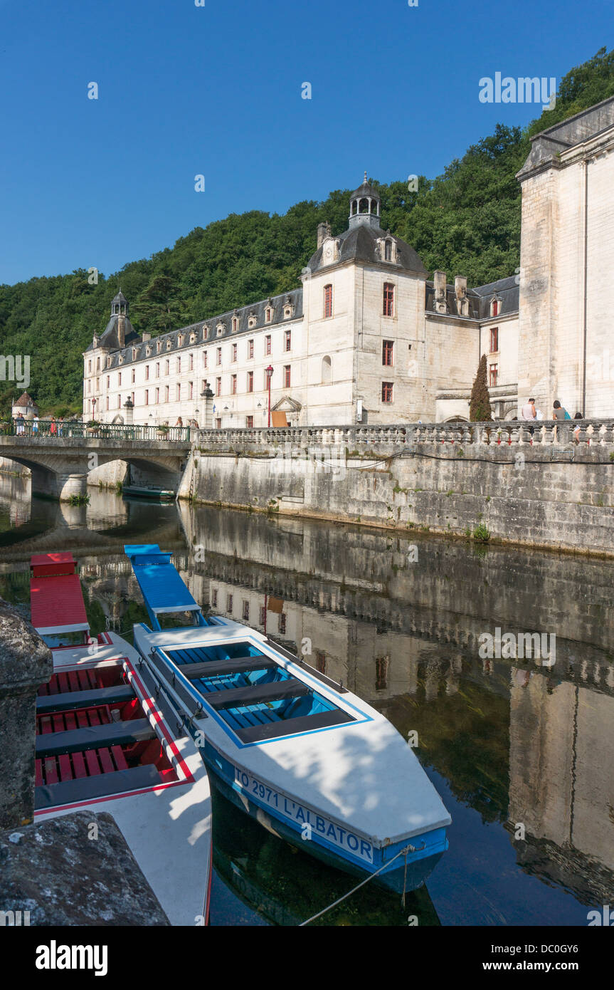 Tour boats on the river Dronne next to the sunlit Benedictine Abbey, in the commune of Brantôme, Dordogne department in south west France, Europe. Stock Photo