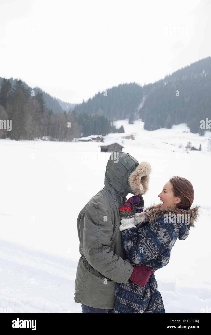 Happy couple hugging in snowy field Stock Photo - Alamy