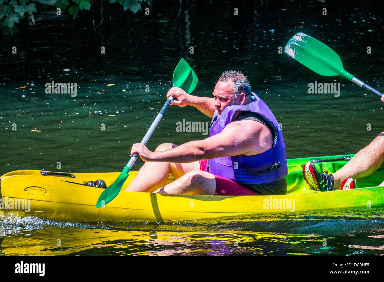 Man in a hire canoe on the river Dronne in the commune of Brantôme, in the Dordogne department in south west France, Europe. Stock Photo