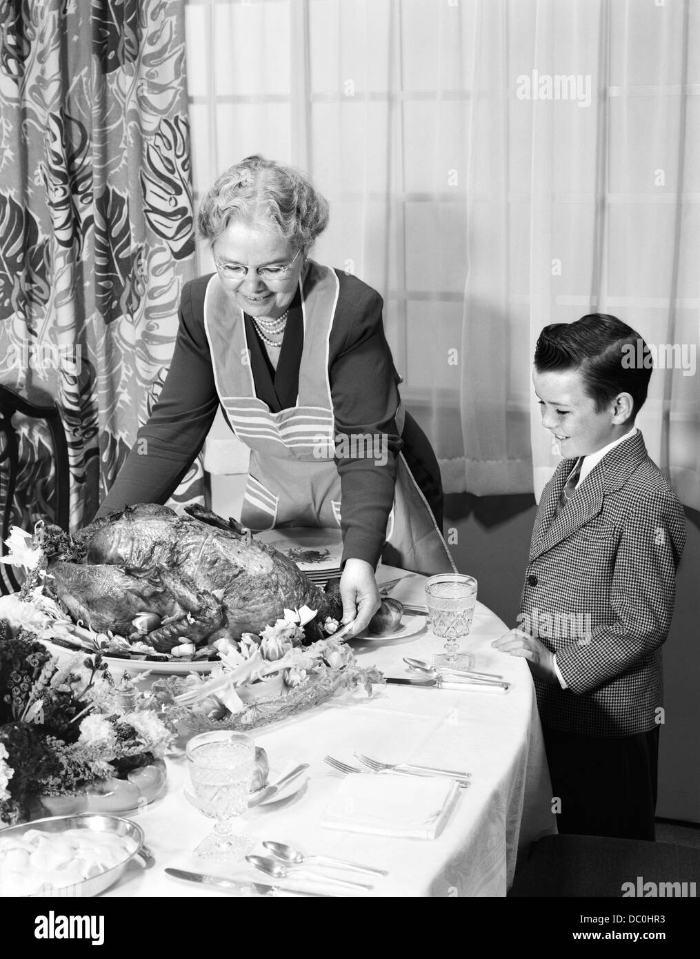 1950s GRANDMOTHER GRANDSON TURKEY THANKSGIVING DINNER Stock Photo