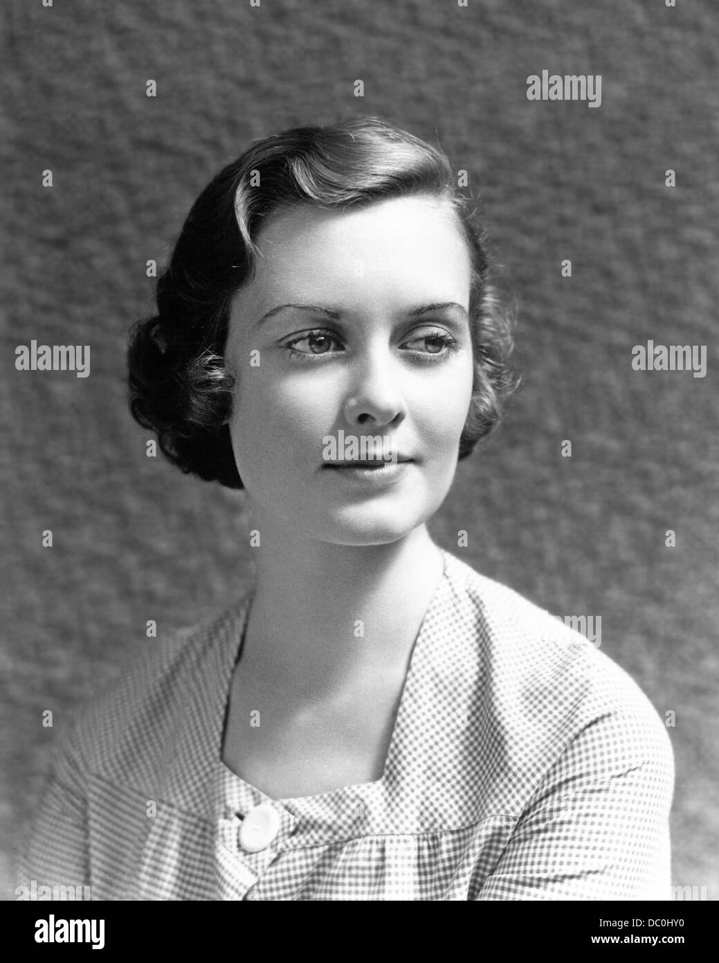 1930s 1940s PORTRAIT WOMAN CHECKED DRESS WITH SUBTLE MONA LISA LIKE SMILE Stock Photo