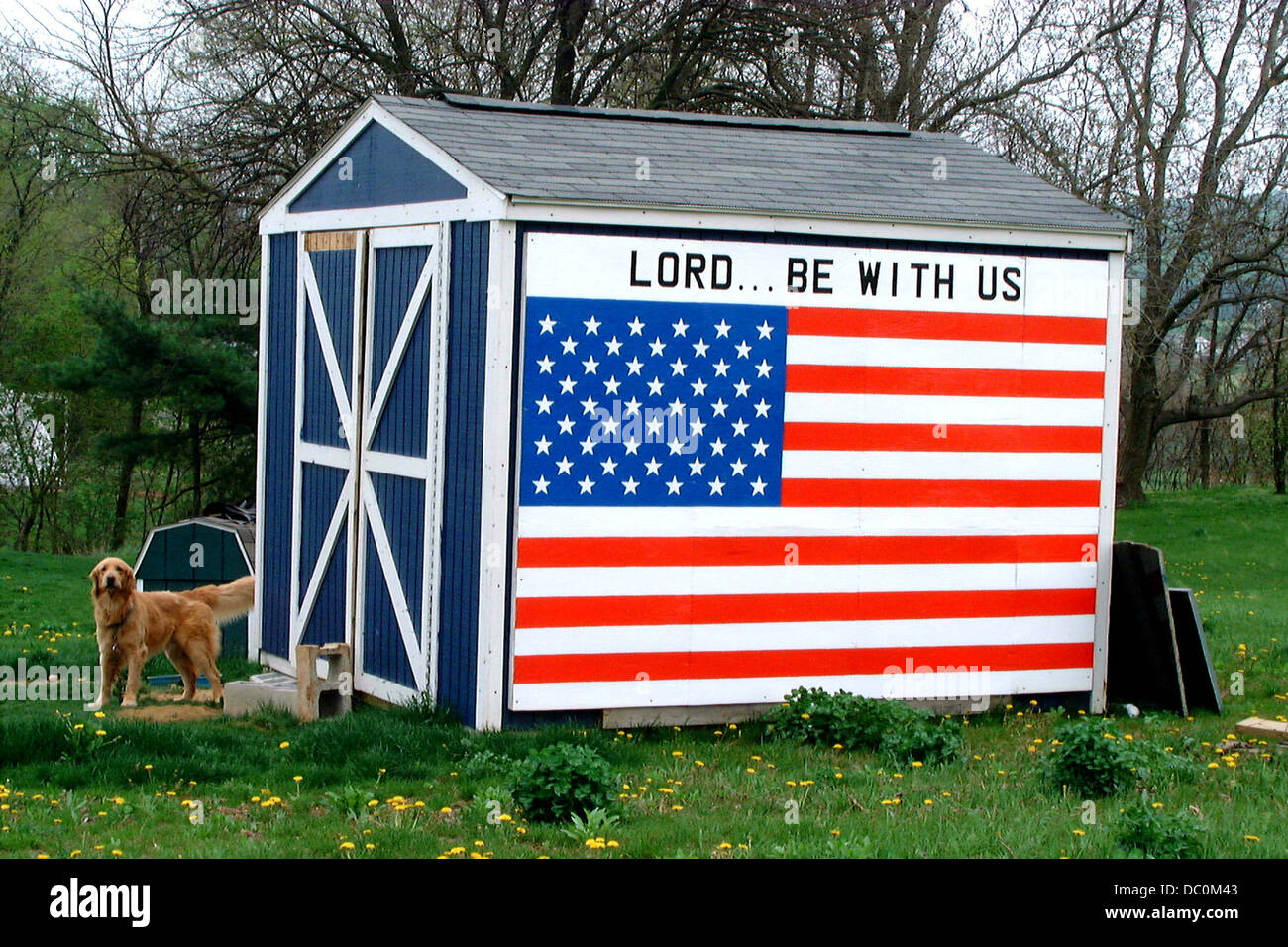 USA FLAG AND LORD BE WITH US SIGN ON SIDE OF TOOL SHED Stock Photo