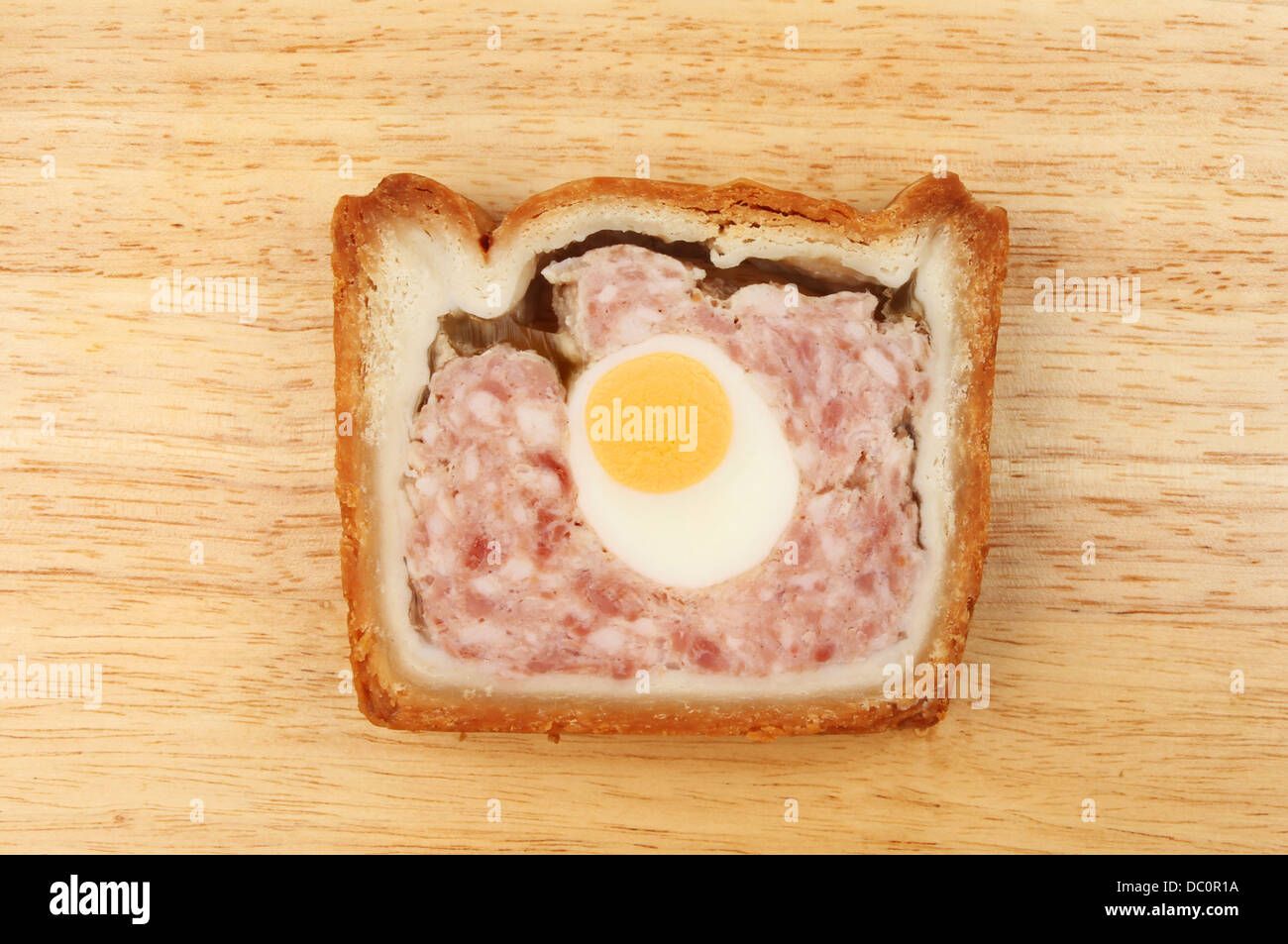 Slice of pork and egg gala pie on a wooden board Stock Photo