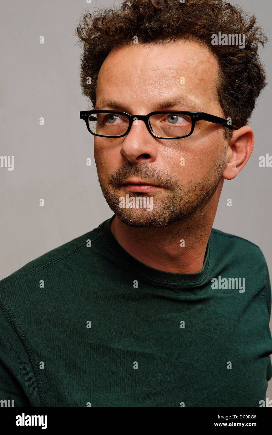 A man with glasses, a green t.shirt and unshaven Stock Photo