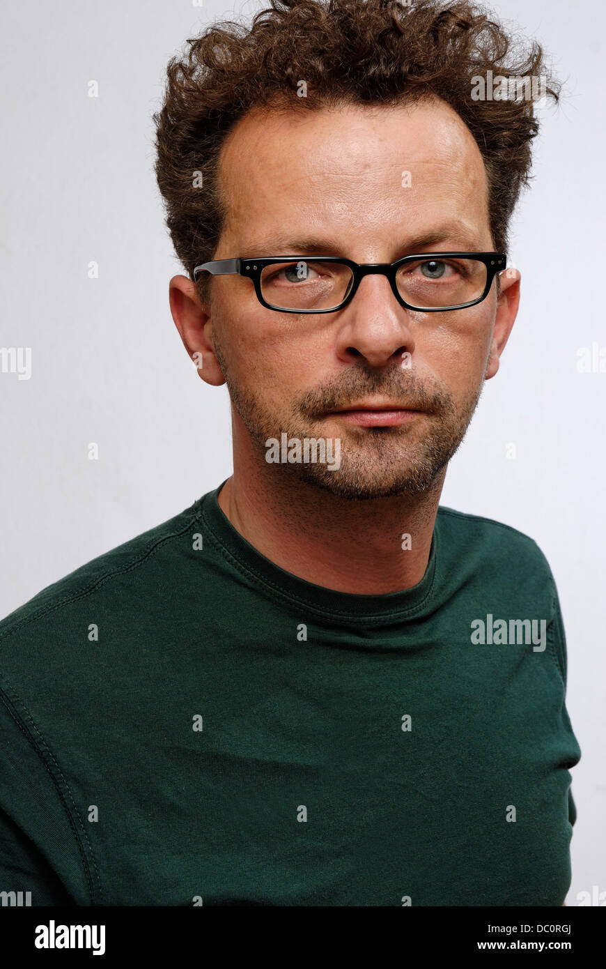 A man with glasses, a green t.shirt and unshaven Stock Photo
