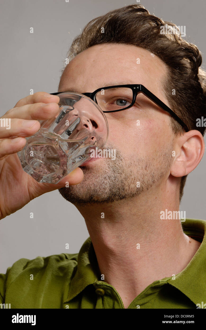 A man drinks a glass of water Stock Photo