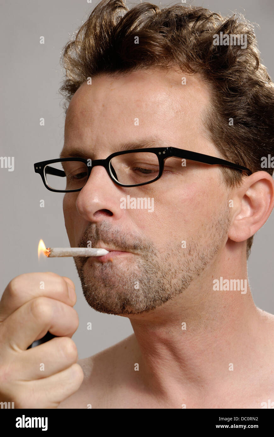 A man lights a cigarette Stock Photo