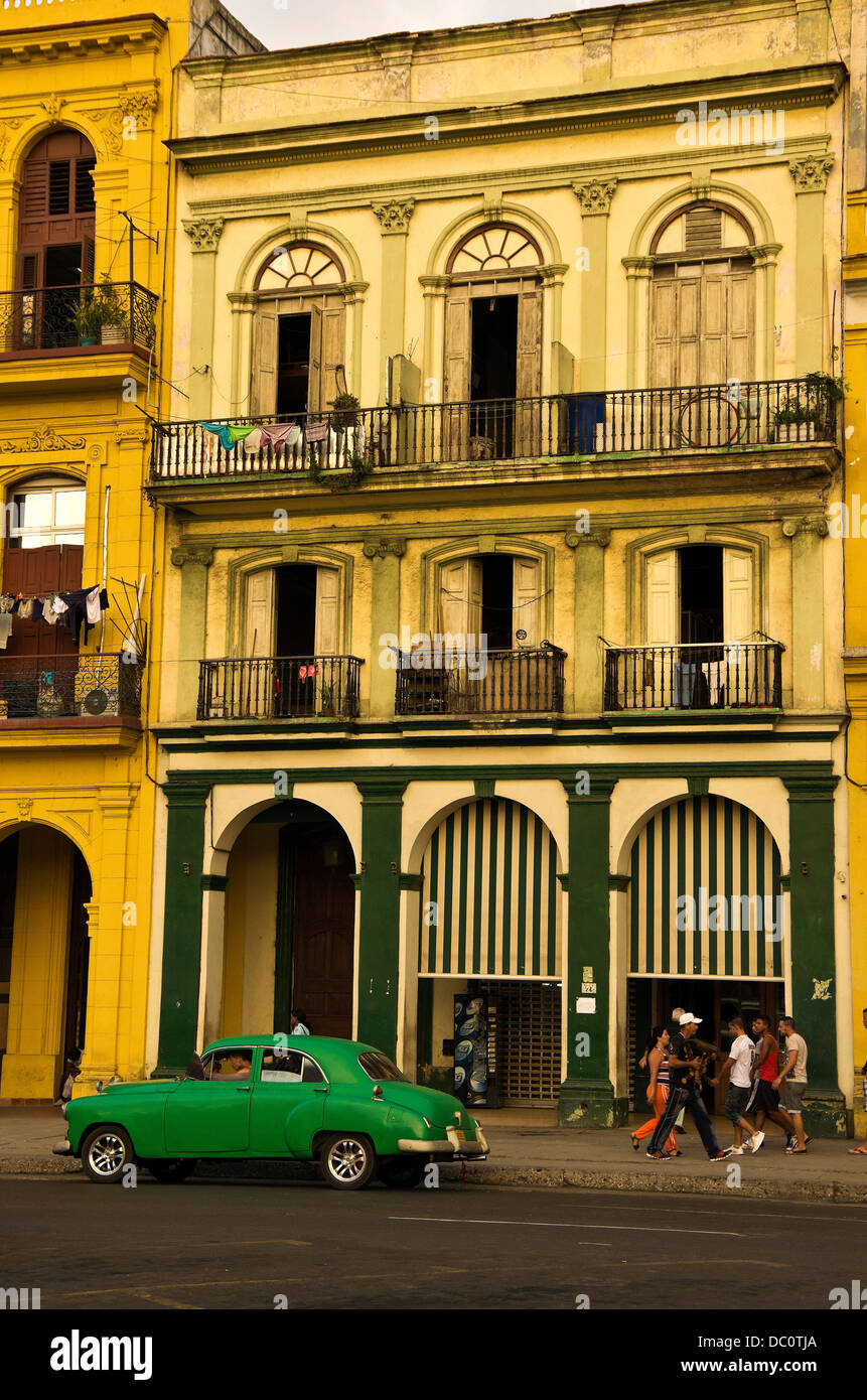 Central Havana 19th century buildings, laundry on balcony, life on the street, green car in front Stock Photo