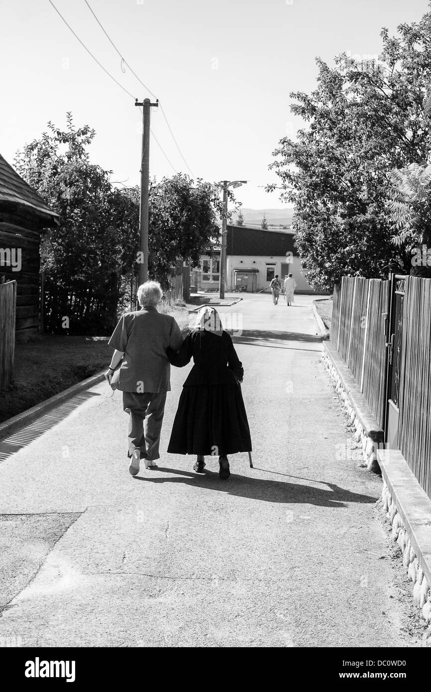 Old woman with daughter going to church at village street Stock Photo