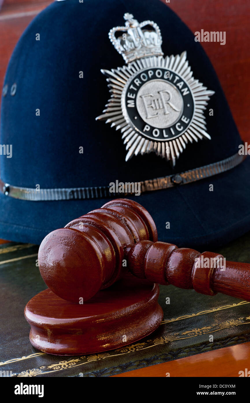 Metropolitan Police helmet with judges gavel in London law courts concept situation UK Stock Photo