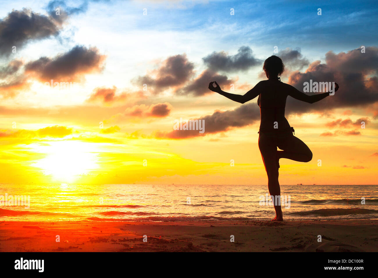 Silhouette young woman practicing yoga on the beach at sunset Stock ...