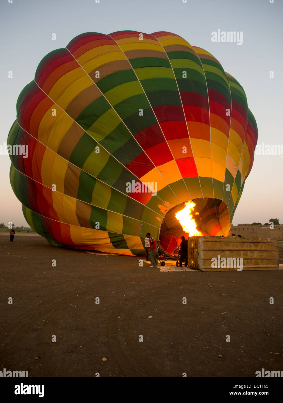 Hot Air Balloon lying on its side being inflated at dawn in Luxor, Egypt Stock Photo