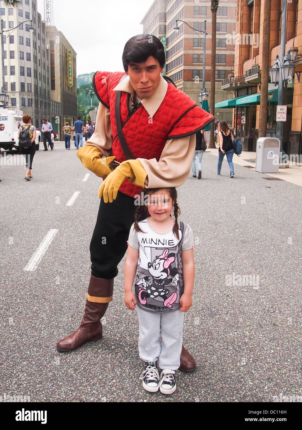 Gaston from the movie Beauty and the Beast leans poses with a young girl at Disneyland Paris in France Stock Photo