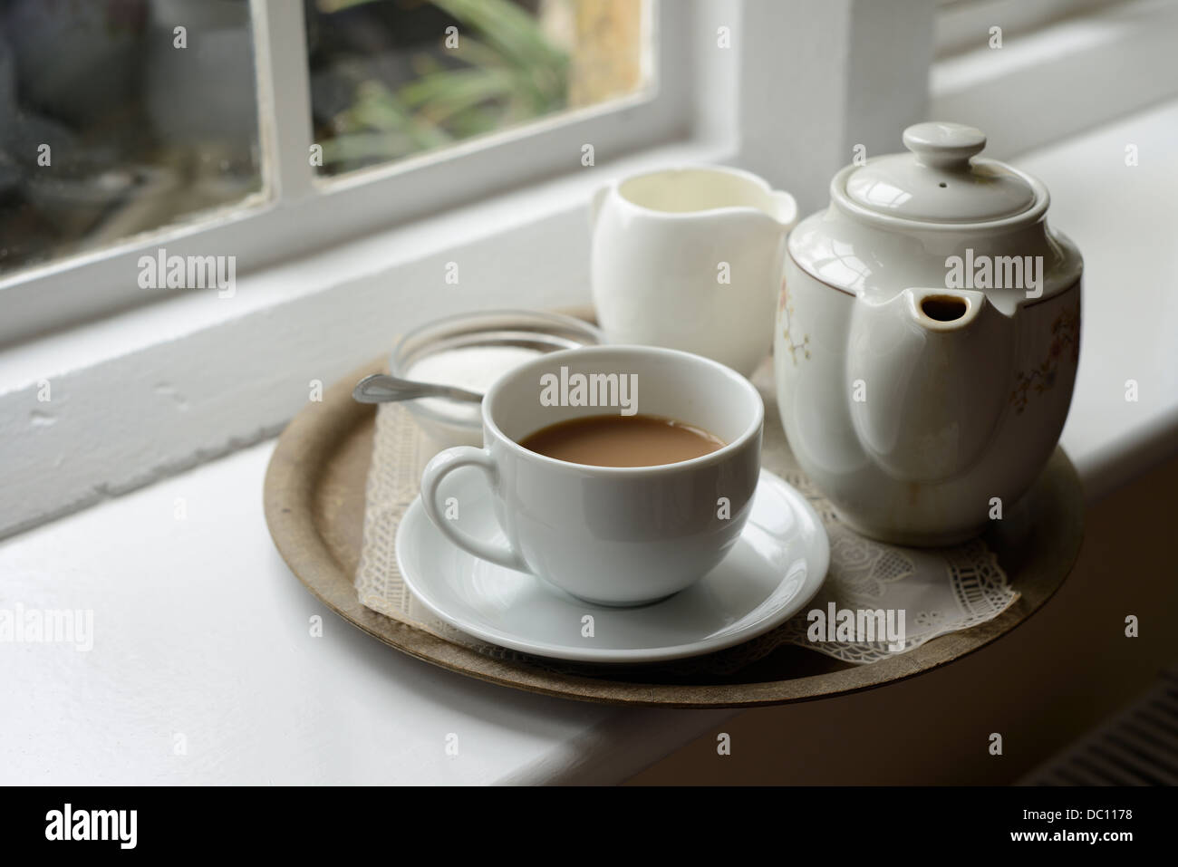 White Teapot Cup Of Tea Jug Of Milk And Bowl Of Sugar On A Tray By Large Window Stock Photo Alamy