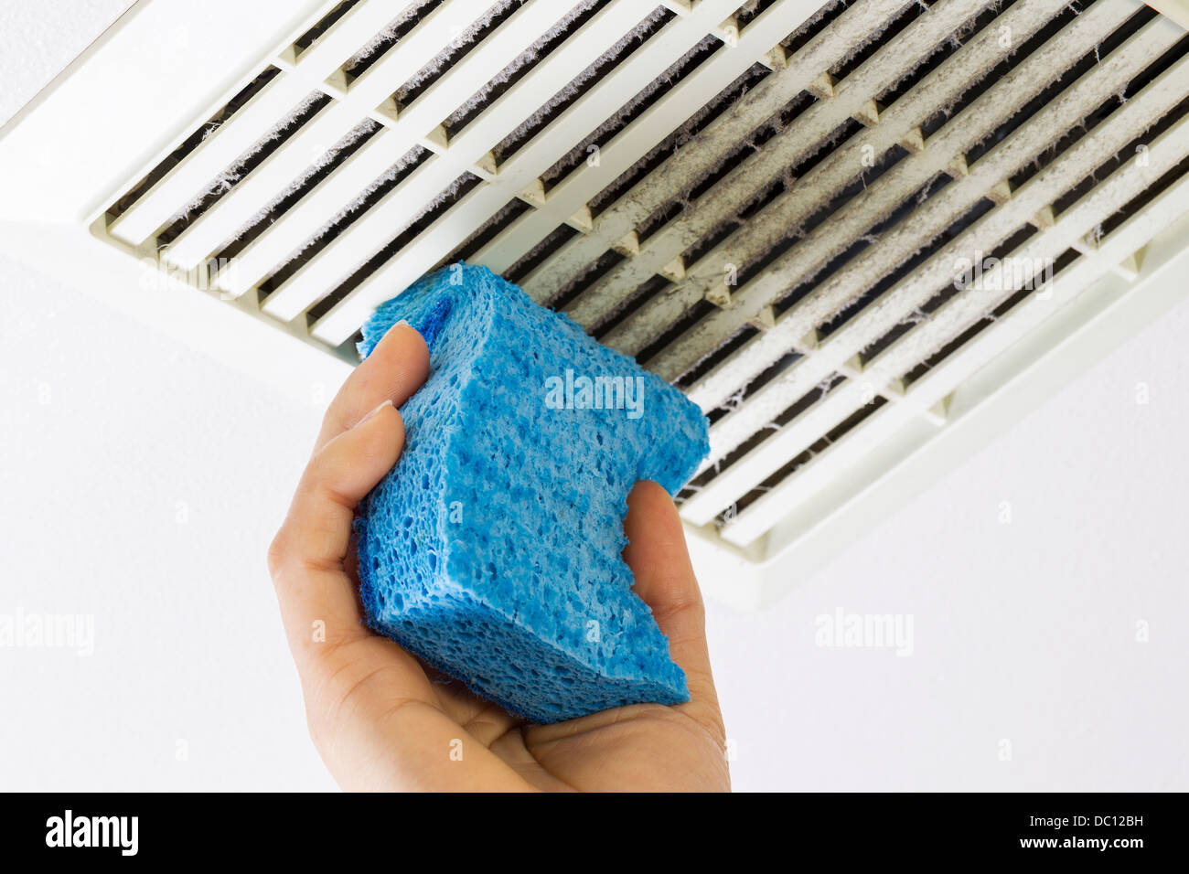 Close up horizontal photo of female hand cleaning dirty bathroom fan