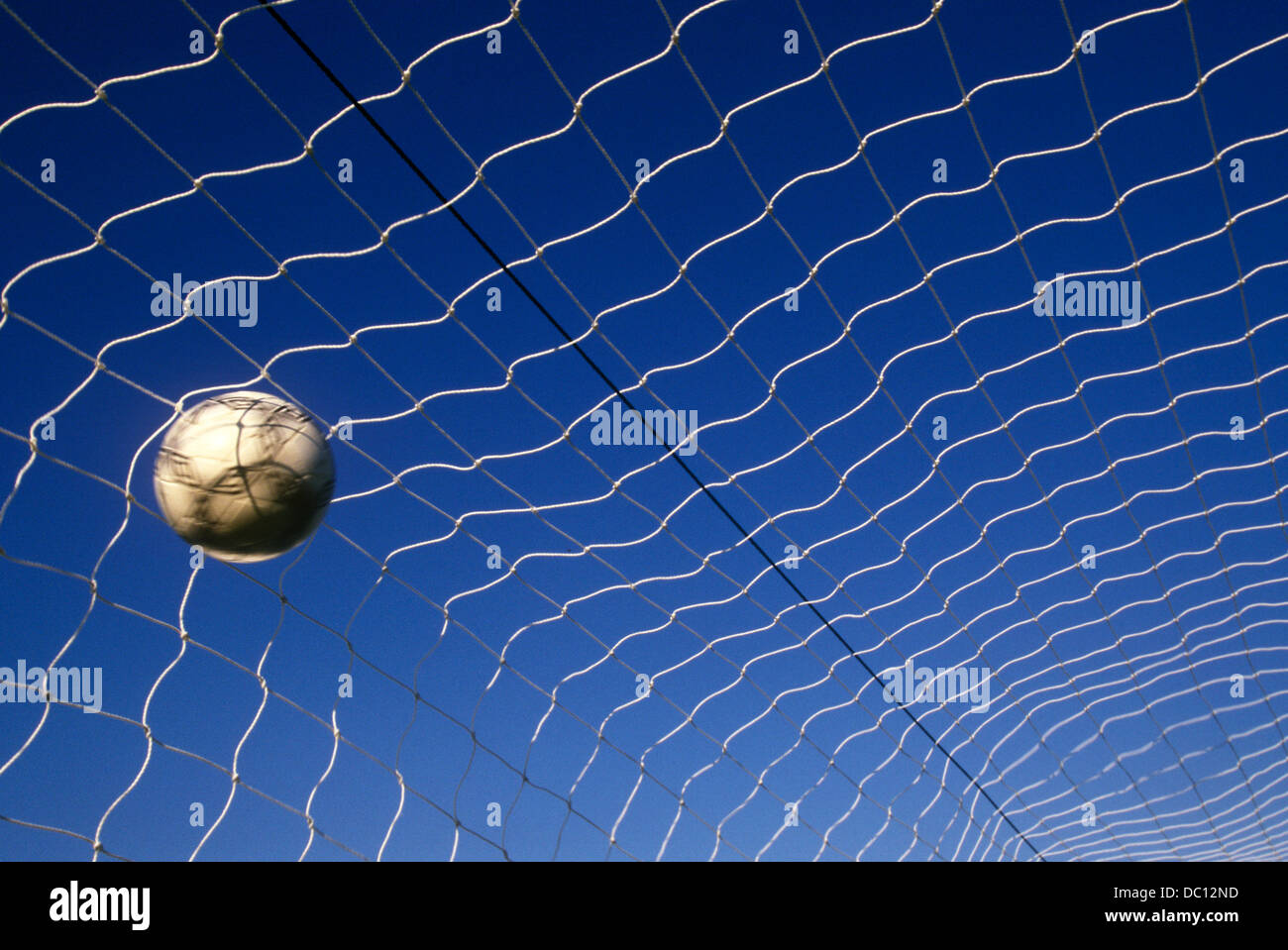 Soccer ball in net indicating a goal. Stock Photo