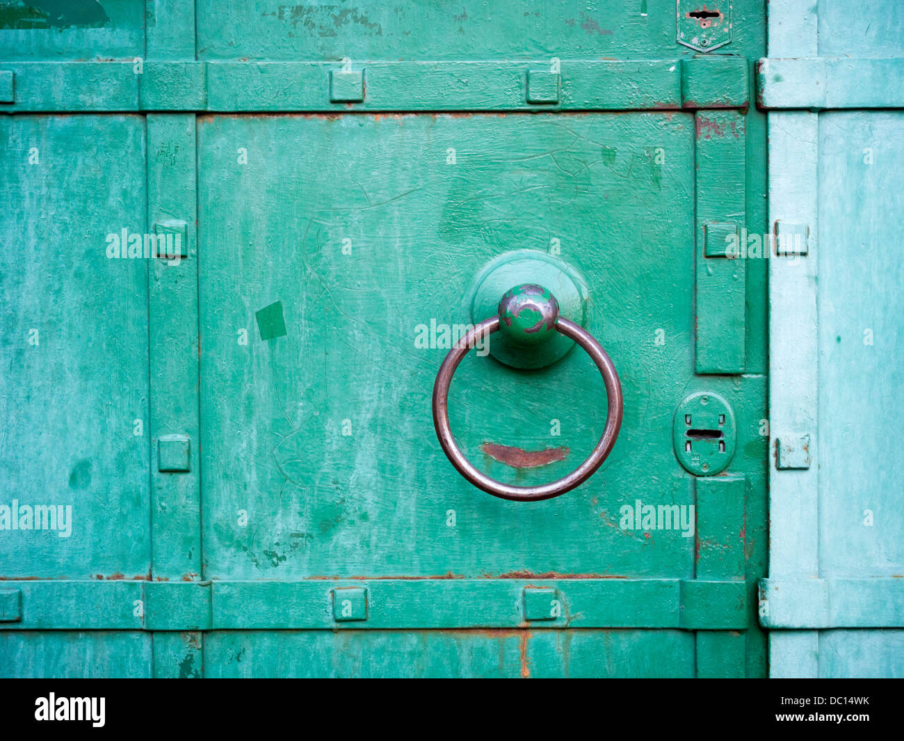 metallic ring handle over green door Stock Photo