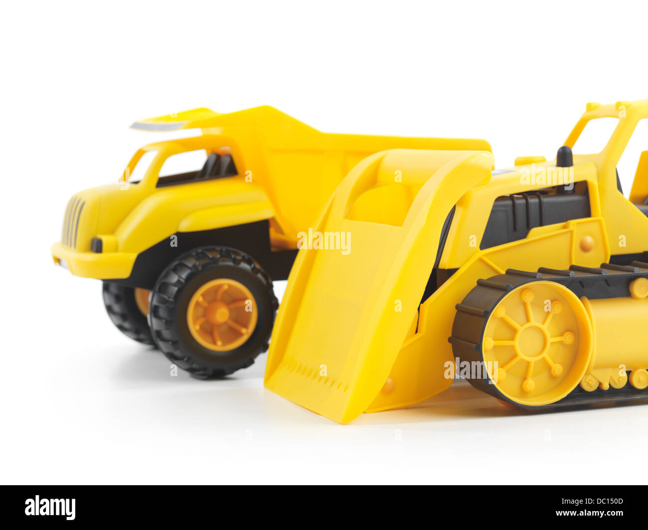 Yellow plastic children toys a bulldozer and a dump truck isolated on white background Stock Photo