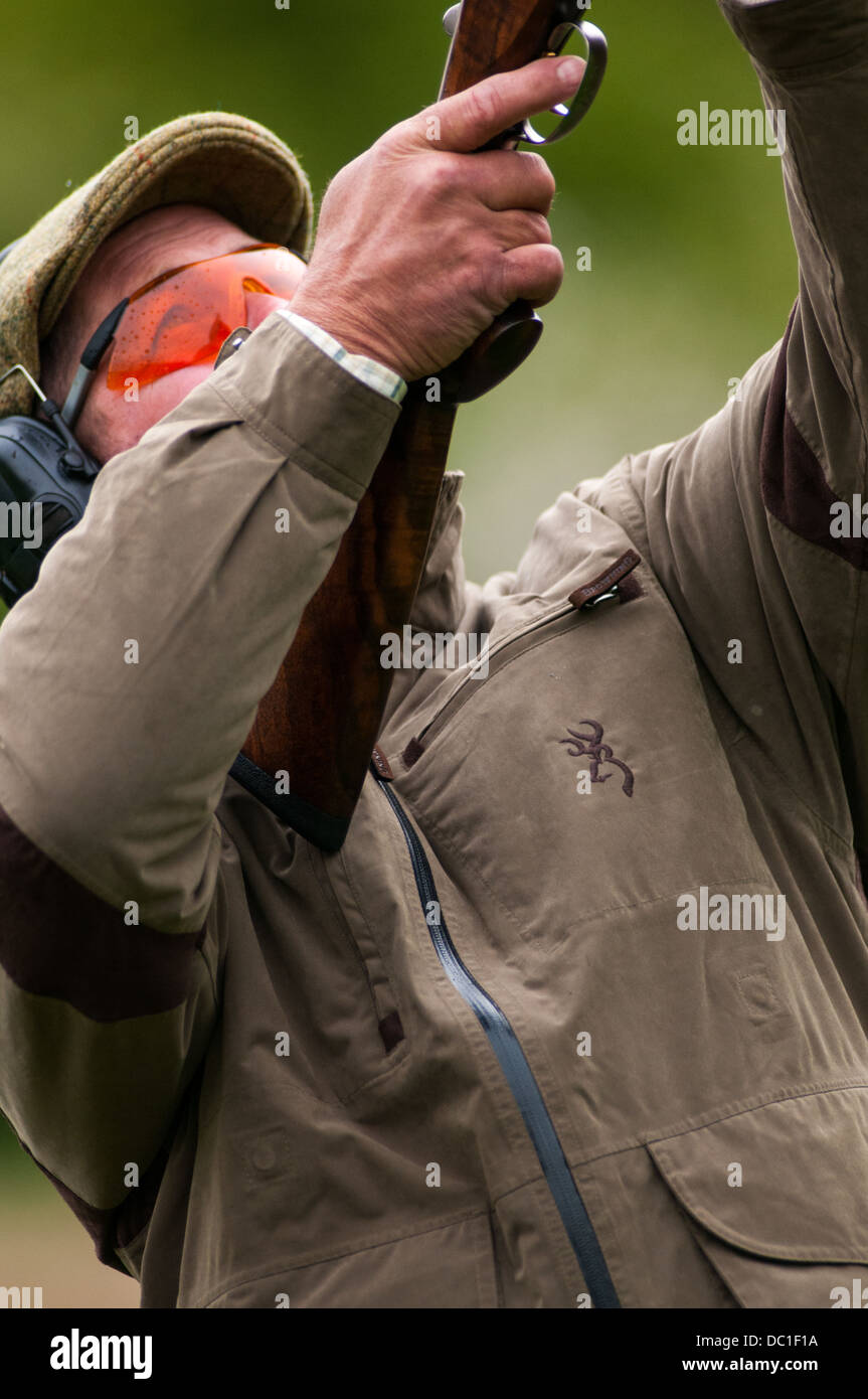 Man shooting at a simulated game shooting clay shoot wearing tweed cap