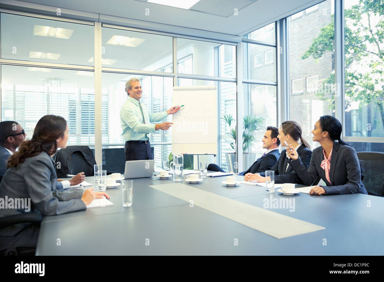 Businessman leading meeting at flipchart in conference room Stock Photo