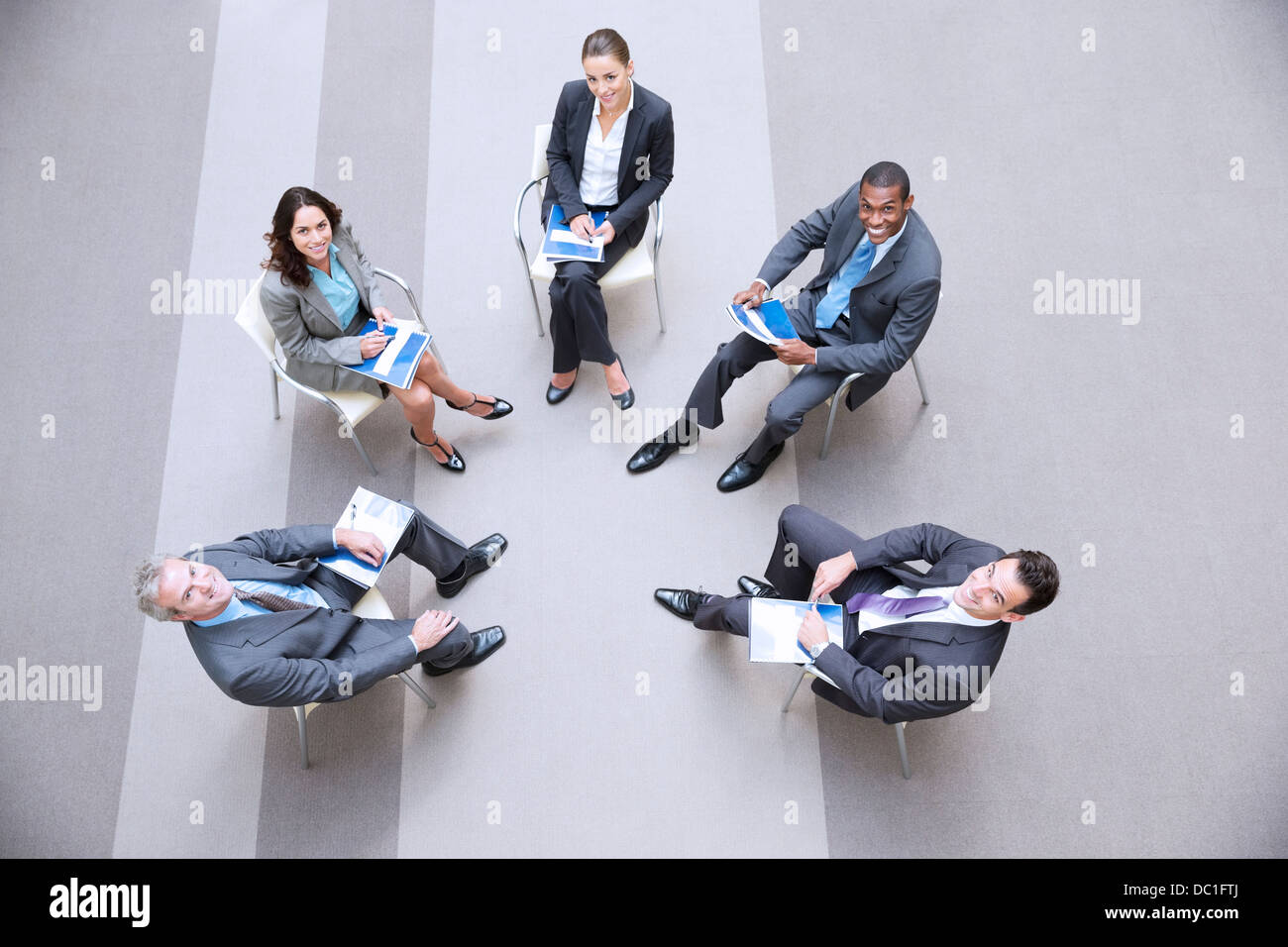 High angle portrait of smiling business people meeting in circle Stock Photo
