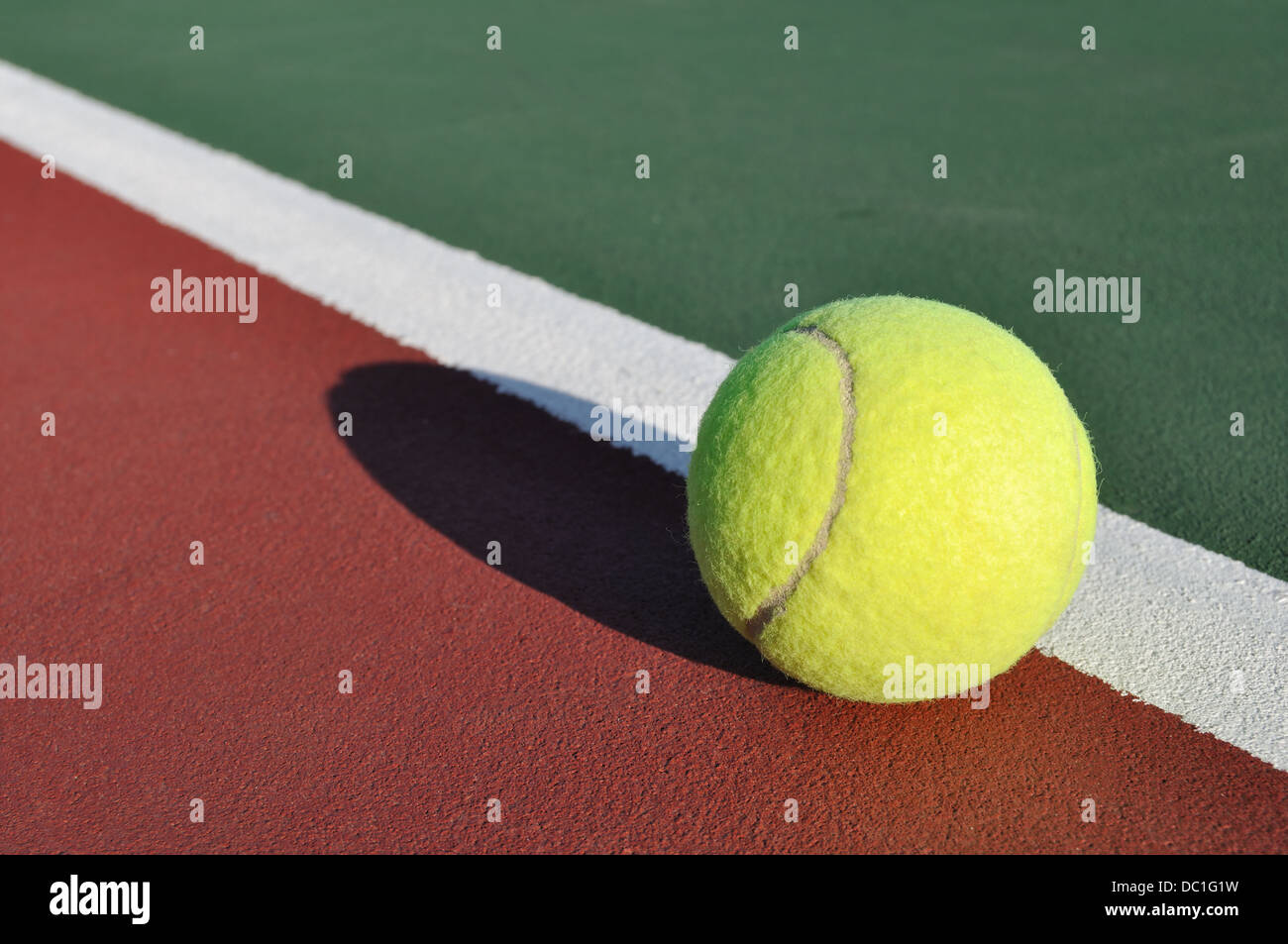 Tennis ball on a court at the baseline Stock Photo