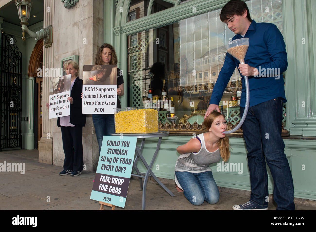 Piccadilly, London, UK. 7th Aug, 2013. Animal rights group, PETA held a protest outside upmarket store, Fortnum & Mason to highlight the suffering caused to geese in the preparation of foie gras. They 'force fed' a woman to show the fear and pain involved in making foie gras. It showed the amount of corn (20kg) the woman would be force fed everyday by a pipe pushed down her throat. Fortnum & Mason are one of the few retailers left selling foie gras in the UK. Credit:  Allsorts Stock Photo/Alamy Live News Stock Photo