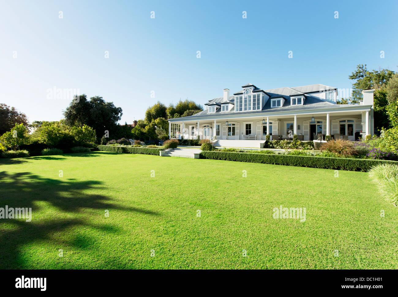 Luxury house facing sunny lawn Stock Photo