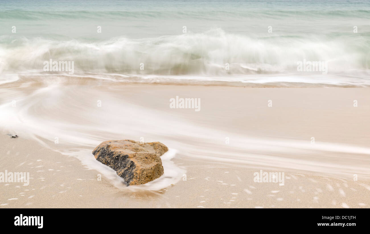 Beautiful yellow sand beach with emerald ocean and rocks Stock Photo ...
