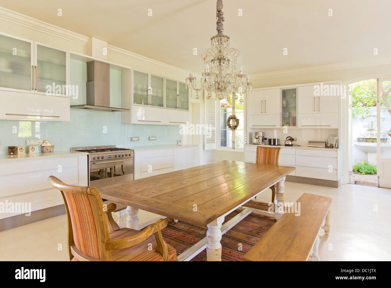 Chandelier over wooden table in kitchen Stock Photo