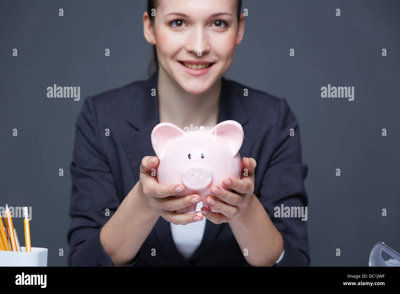 Image of pink piggy bank held by smiling female Stock Photo - Alamy