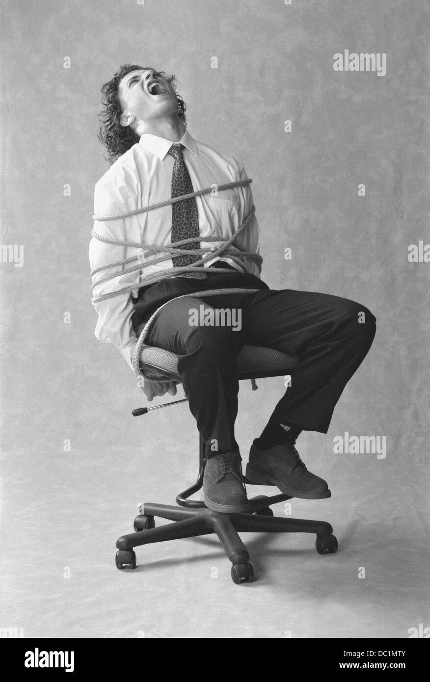 Man tied to chair Black and White Stock Photos & Images - Alamy
