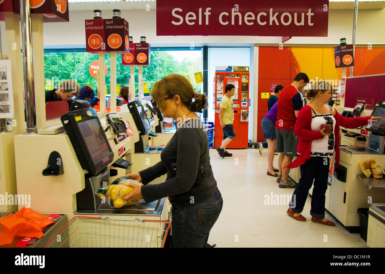 Customers using self service checkout at Sainsburys supermarket Stock