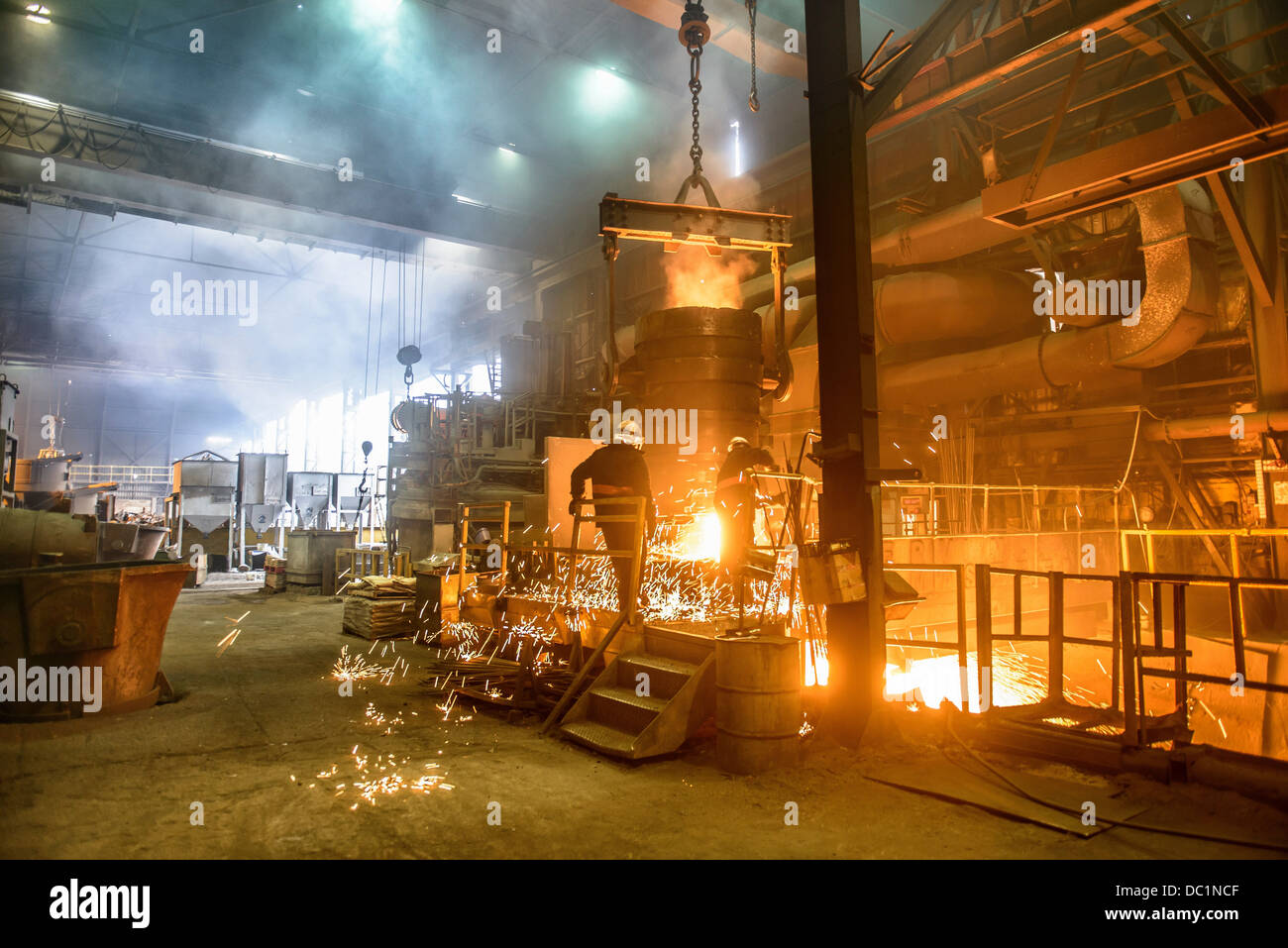 Steel workers watching furnace in steel foundry Stock Photo