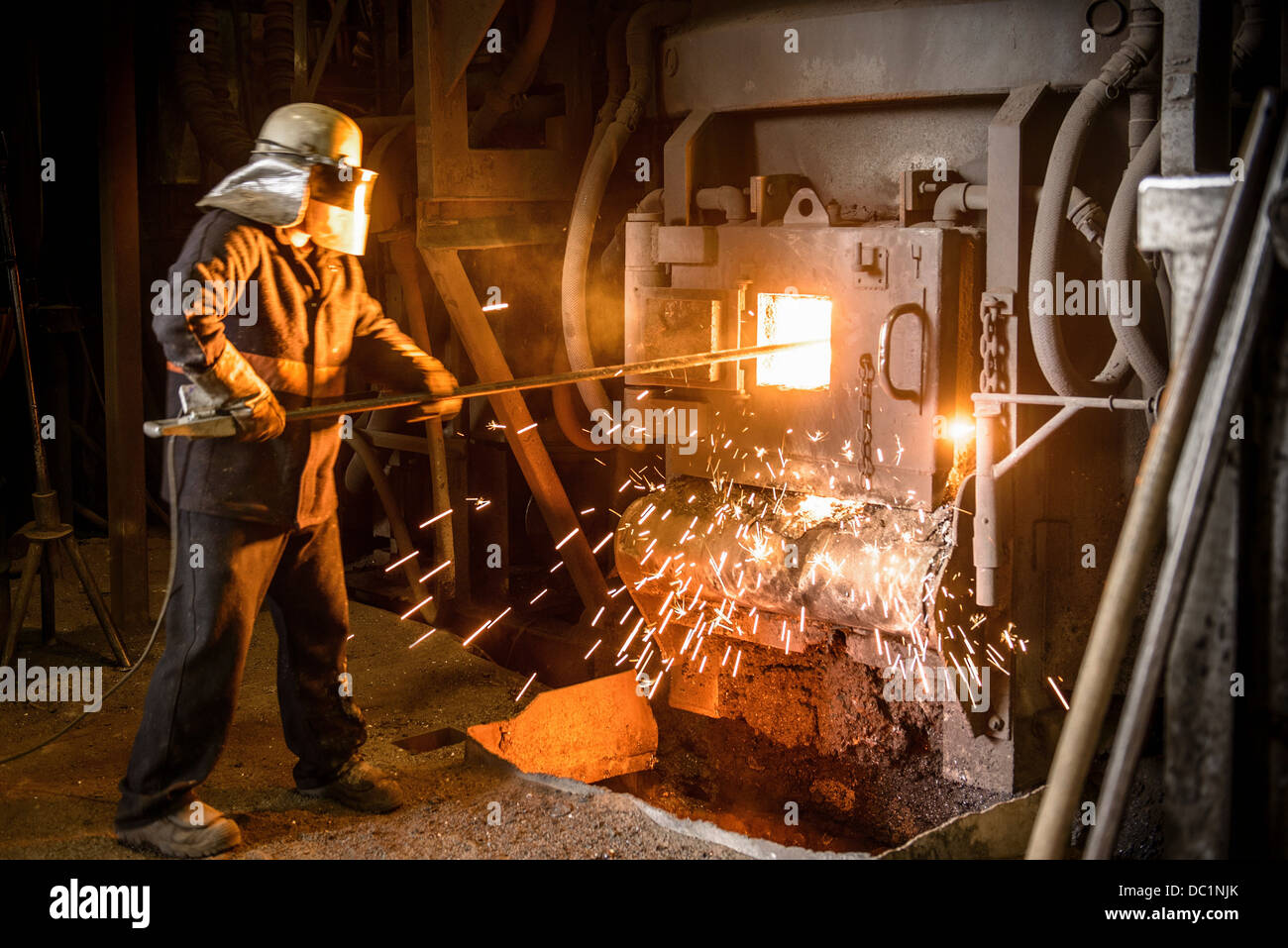 Steel worker in front of furnace in steel foundry Stock Photo