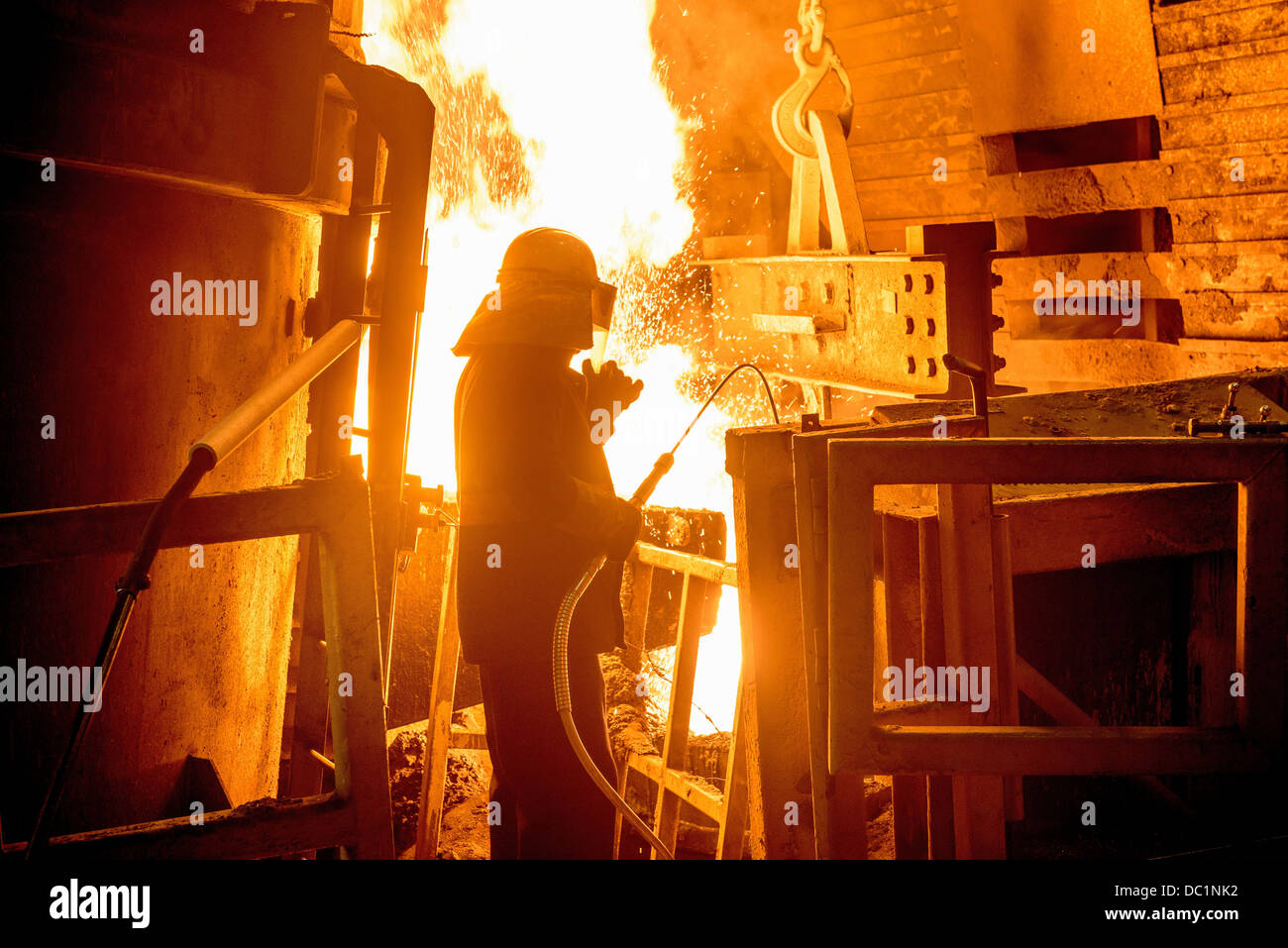 Steel worker in front of furnace fire in steel foundry Stock Photo