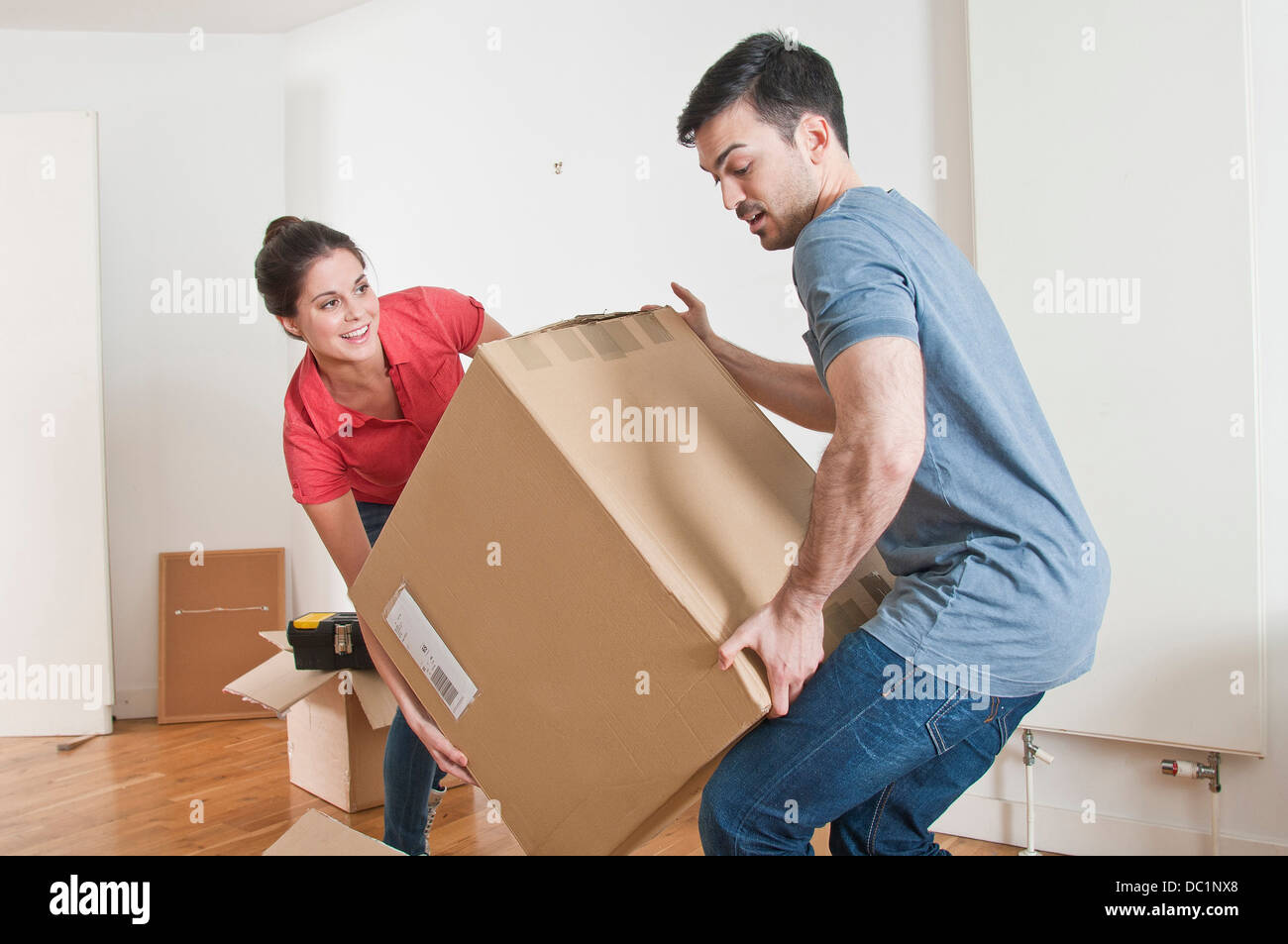 Young couple lifting cardboard box Stock Photo